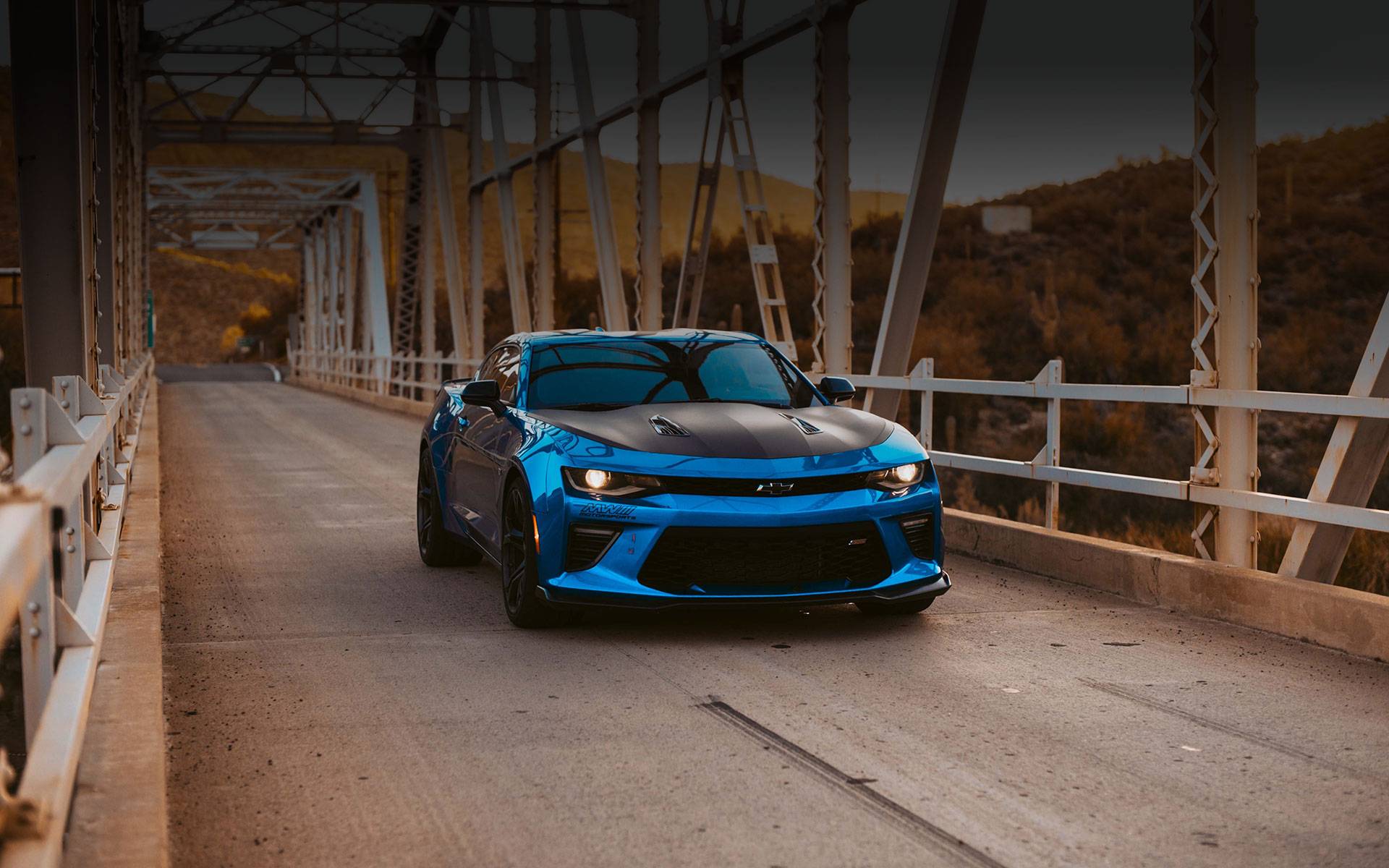 Blue Camaro crossing over bridge